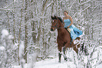 Frau reitet im Kleid durch den Schnee