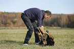 Mann spielt mit Groem Schweizer Sennenhund