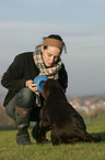 Frau spielt mit Labrador Welpe