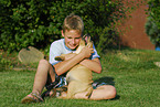 Junge und Labrador Retriever Welpe