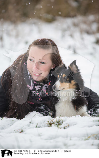 Frau liegt mit Sheltie im Schnee / woman lays with sheltie in snow / RR-79204