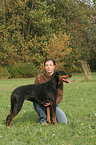 Frau kuschelt mit Dobermann