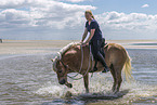 Frau reitet Haflinger