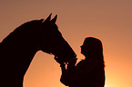 Pferd und Mensch im Sonnenuntergang