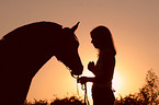 Frau mit Pferd im Sonnenuntergang
